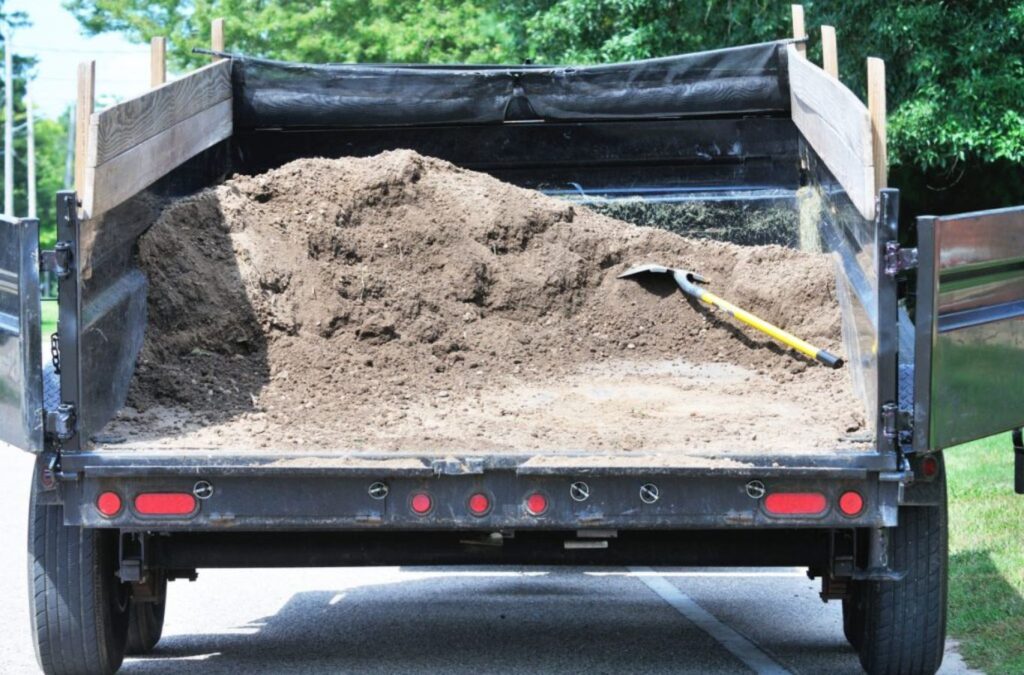 A Hauling 24/7 team member delivering dirt and gravel removal in Goleta, CA, showcasing equipment and proper disposal techniques.