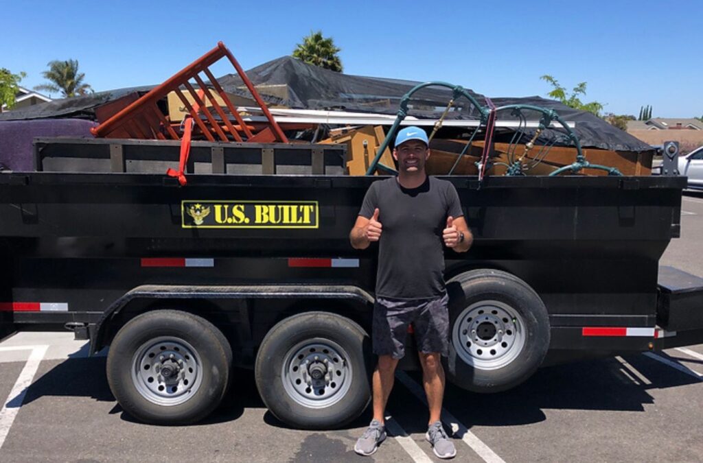 A Hauling 24/7 crew member efficiently handling green waste removal in Goleta, CA, demonstrating proper tools and techniques for eco-friendly waste management.